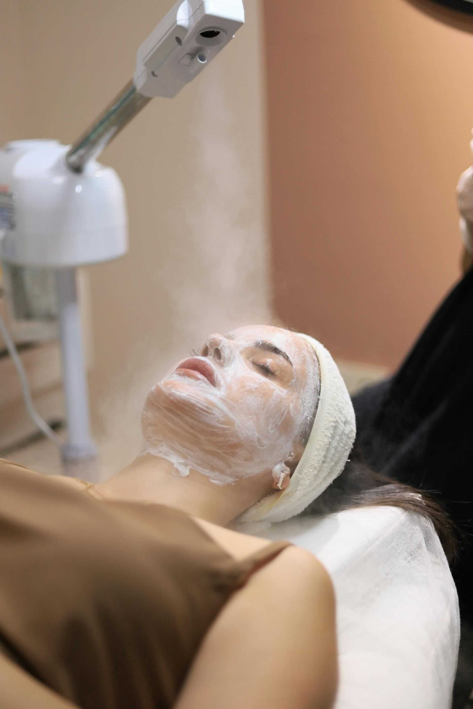 Facial treatment with steam and mask at a spa.